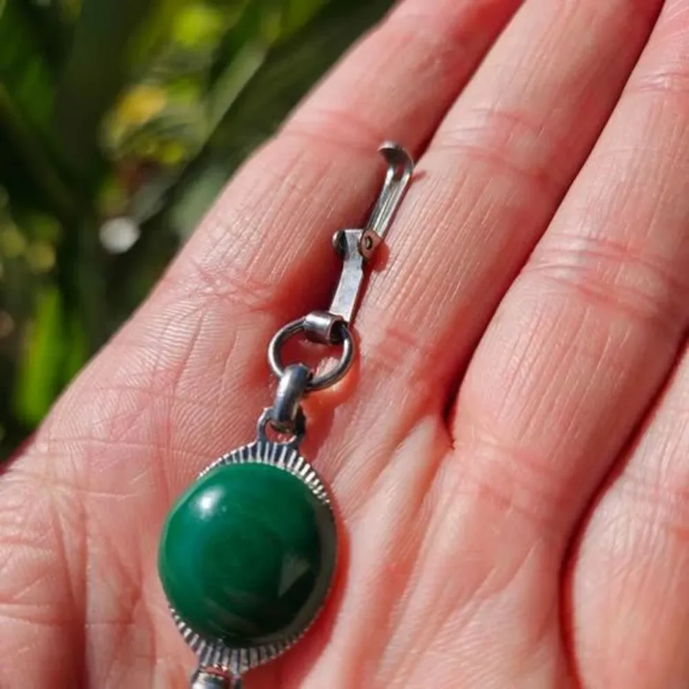 Malachite bracelet features natural green gemstones set in a silver colored link